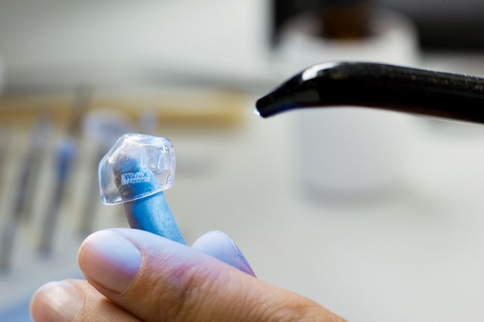 Widex Mann haelt Ohrpasstueck